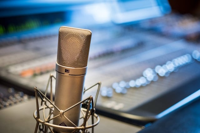 a microphone on a desk, a computer in the background